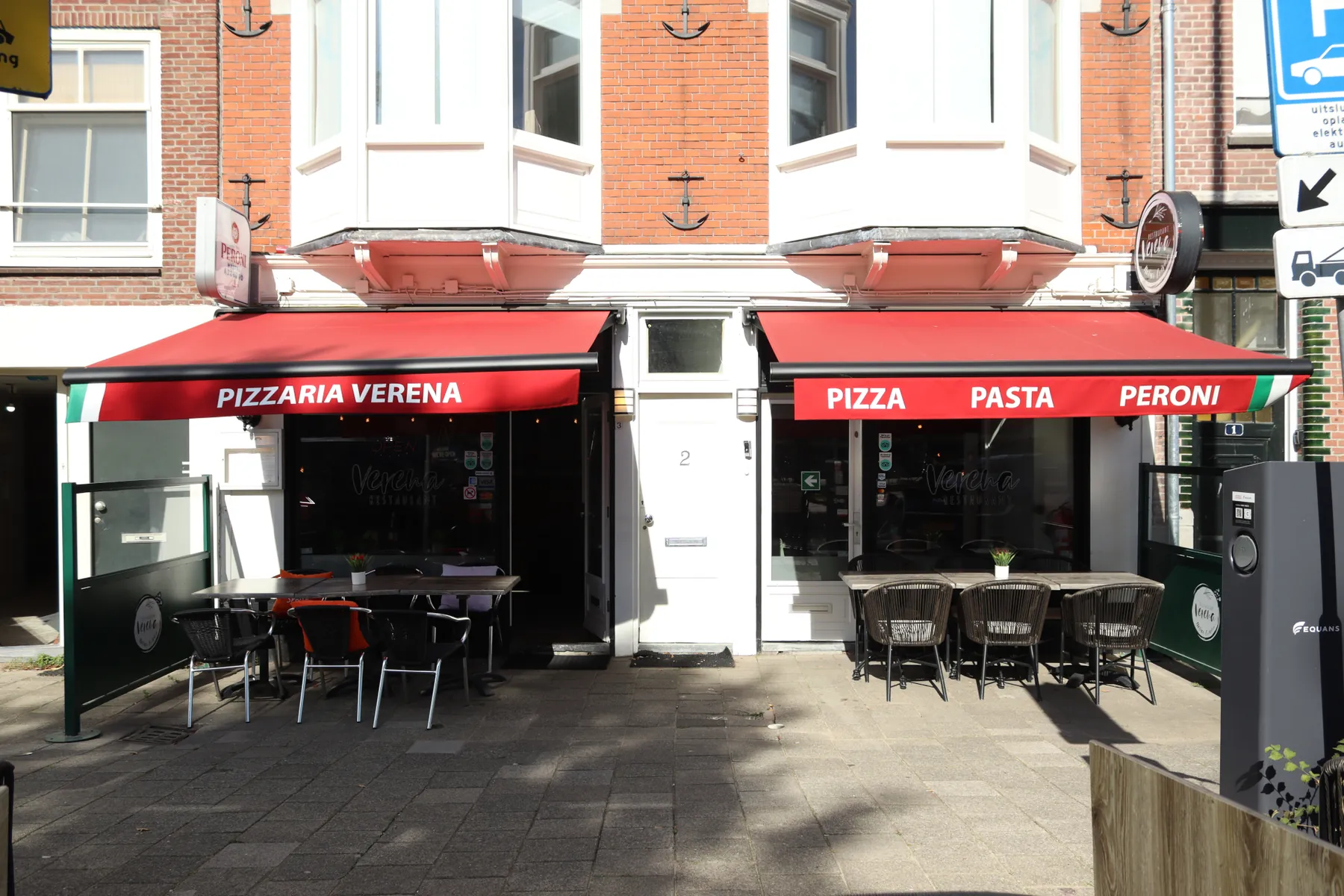 Het terras van Restaurant Verena met uitgeklapte rode zonneschermen