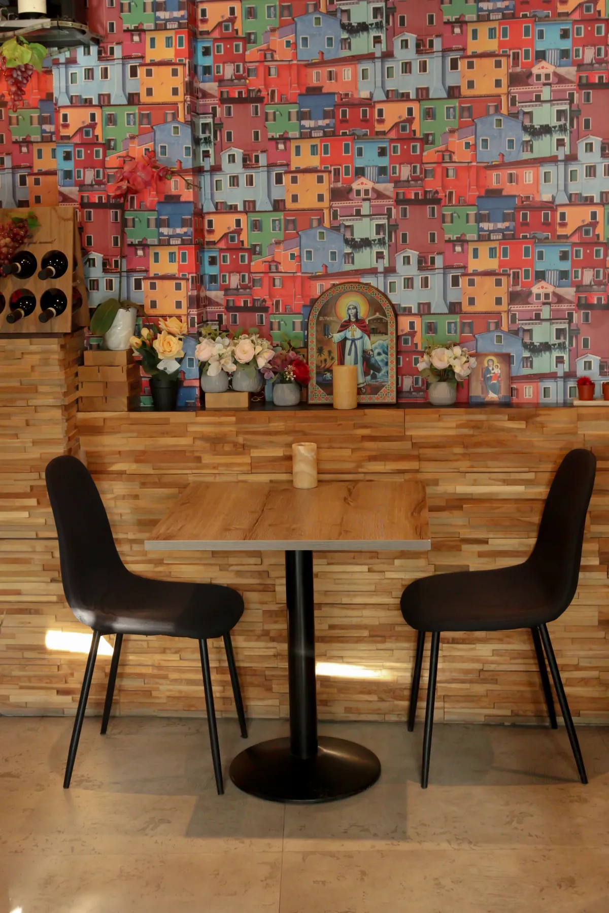 Het wandbehang met Italiaanse vissershuisjes achter een gedekte tafel